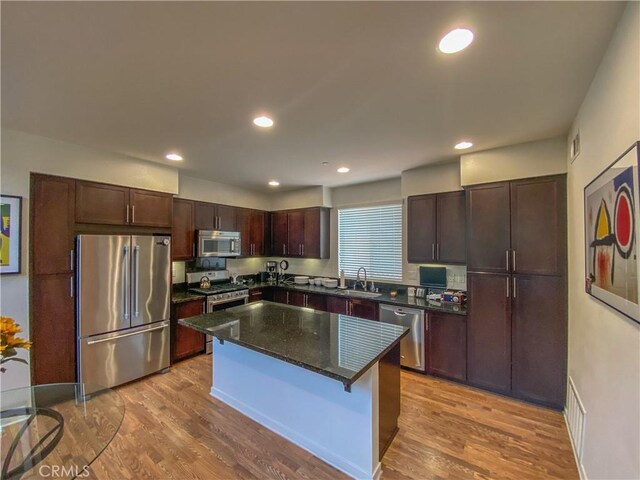 5 Abarrota St, Rancho Mission Viejo, CA 92694 - kitchen with appliances with stainless steel finishes, a sink, dark brown cabinetry, wood finished floors, and recessed lighting