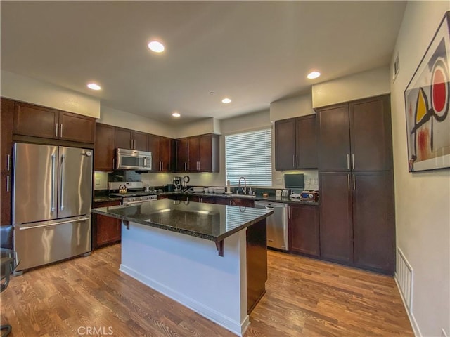 5 Abarrota St, Rancho Mission Viejo, CA 92694 - kitchen with stainless steel appliances, dark brown cabinets, a kitchen island, wood finished floors, and recessed lighting