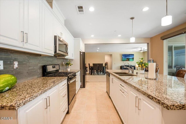 30106 Stargazer Way, Menifee, CA 92584 - kitchen featuring appliances with stainless steel finishes, a sink, decorative backsplash, white cabinets, and decorative light fixtures
