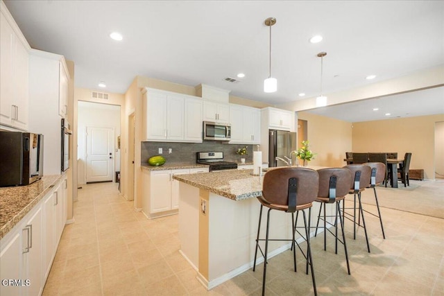 30106 Stargazer Way, Menifee, CA 92584 - kitchen featuring stainless steel appliances, backsplash, a center island with sink, recessed lighting, and white cabinetry