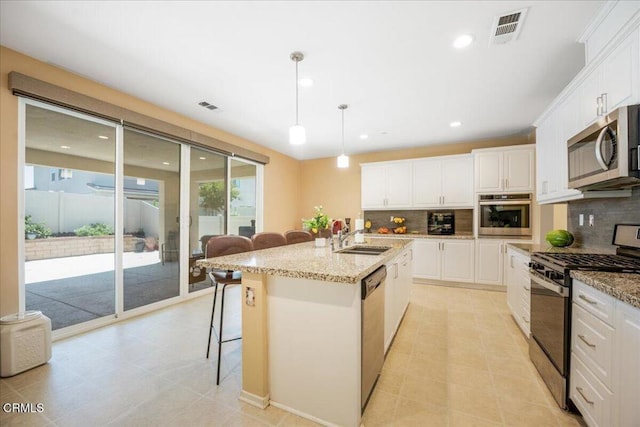 30106 Stargazer Way, Menifee, CA 92584 - kitchen featuring stainless steel appliances, a sink, a breakfast bar area, backsplash, and white cabinetry
