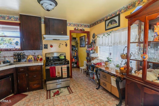 153 E Date St, Oxnard, CA 93033 - kitchen with gas stove, under cabinet range hood, tile countertops, and healthy amount of natural light