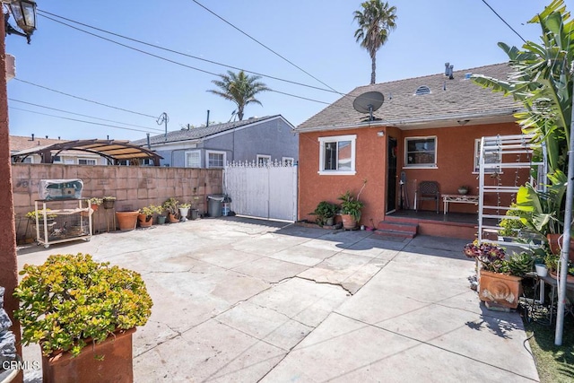 153 E Date St, Oxnard, CA 93033 - back of property with a patio, stucco siding, roof with shingles, and a gate