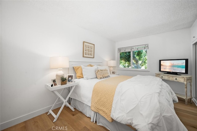 13400 Del Monte Unit 1M, Seal Beach, CA 90740 - bedroom with wood finished floors, a textured ceiling, and baseboards