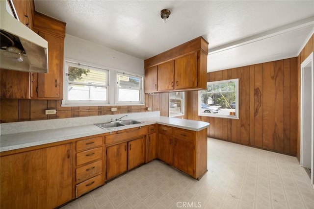 1427 Beach St, San Luis Obispo, CA 93401 - kitchen with light countertops, a sink, a peninsula, under cabinet range hood, and light flooring