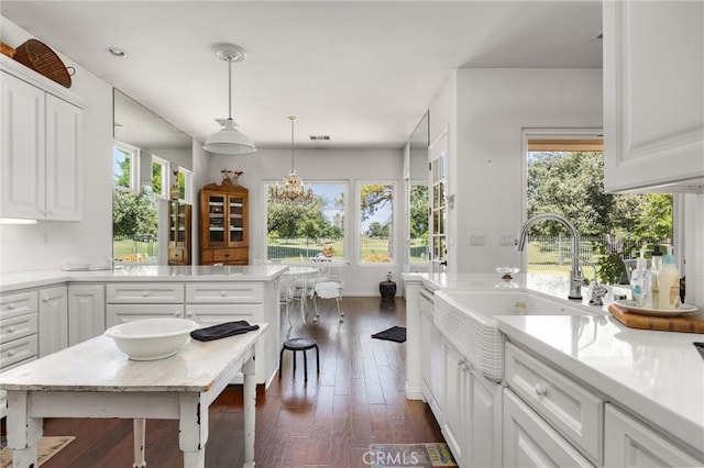 2403 Crocus Dr, Bakersfield, CA 93311 - kitchen with white cabinets, light countertops, dark wood-type flooring, a sink, and pendant lighting