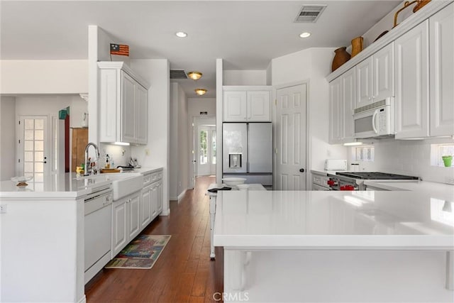 2403 Crocus Dr, Bakersfield, CA 93311 - kitchen with white appliances, a peninsula, a sink, tasteful backsplash, and recessed lighting