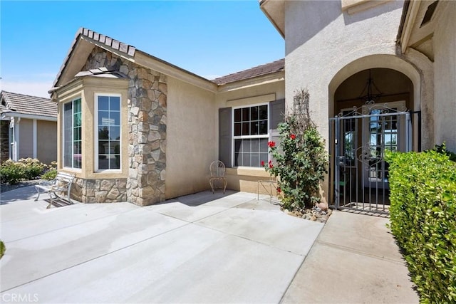 2403 Crocus Dr, Bakersfield, CA 93311 - doorway to property featuring stone siding, stucco siding, and a patio area