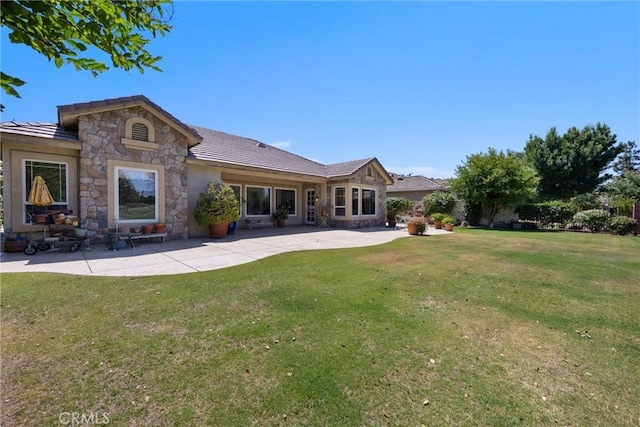 2403 Crocus Dr, Bakersfield, CA 93311 - rear view of house featuring stone siding, a lawn, a patio area, a tiled roof, and stucco siding