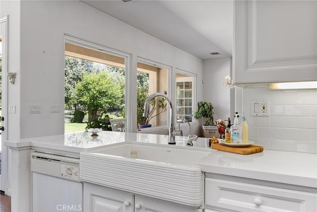 2403 Crocus Dr, Bakersfield, CA 93311 - kitchen with dishwasher, a sink, backsplash, light countertops, and white cabinetry