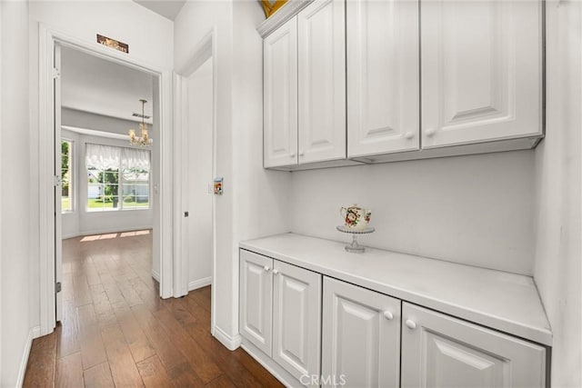 2403 Crocus Dr, Bakersfield, CA 93311 - corridor with dark wood finished floors, baseboards, and a chandelier