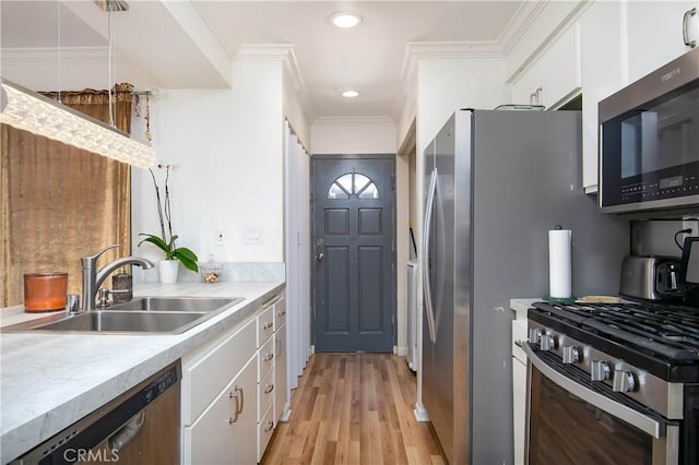 28729 Conejo View Dr, Agoura Hills, CA 91301 - kitchen with stainless steel appliances, a sink, white cabinetry, crown molding, and light wood-type flooring