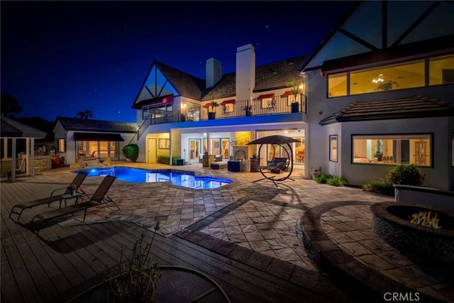 1532 Kensing Ln, North Tustin, CA 92705 - pool at twilight featuring an outdoor pool, an outdoor living space with a fire pit, a patio, and a wooden deck