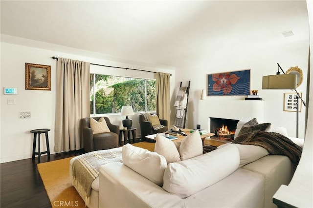 2319 S Corning St, Los Angeles, CA 90034 - living area featuring dark wood-style flooring, a warm lit fireplace, and baseboards