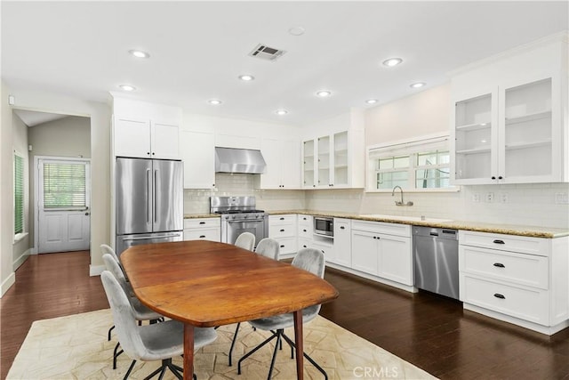36475 Avenida La Cresta, Murrieta, CA 92562 - kitchen featuring appliances with stainless steel finishes, wall chimney exhaust hood, dark wood-type flooring, glass insert cabinets, and recessed lighting