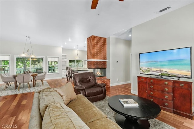 36475 Avenida La Cresta, Murrieta, CA 92562 - living area with baseboards, light wood-type flooring, a ceiling fan, and a brick fireplace