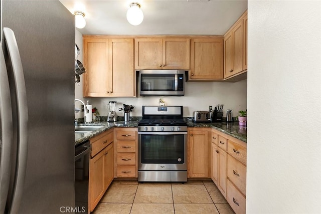 399 N Ironpike Cir Unit 18, Anaheim, CA 92807 - kitchen featuring stainless steel appliances, a sink, light tile patterned flooring, dark stone counters, and light brown cabinetry