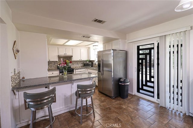 18353 Hackberry St, Hesperia, CA 92345 - kitchen featuring appliances with stainless steel finishes, a peninsula, white cabinets, and dark stone finish floors