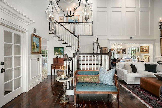 22372 Harwich Ln, Huntington Beach, CA 92646 - living area featuring a chandelier, a decorative wall, stairway, hardwood / wood-style flooring, and a high ceiling