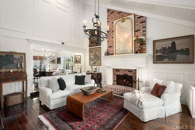 22372 Harwich Ln, Huntington Beach, CA 92646 - living area featuring a chandelier, a decorative wall, dark wood-style floors, a brick fireplace, and beam ceiling