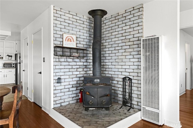814 Natures Way, Paradise, CA 95969 - detailed view of a heating unit, stainless steel microwave, a wood stove, wood finished floors, and baseboards