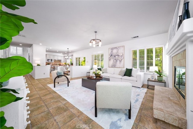 12800 N Overlook Dr, Rancho Cucamonga, CA 91739 - living area featuring stone tile floors, recessed lighting, a fireplace, and a chandelier