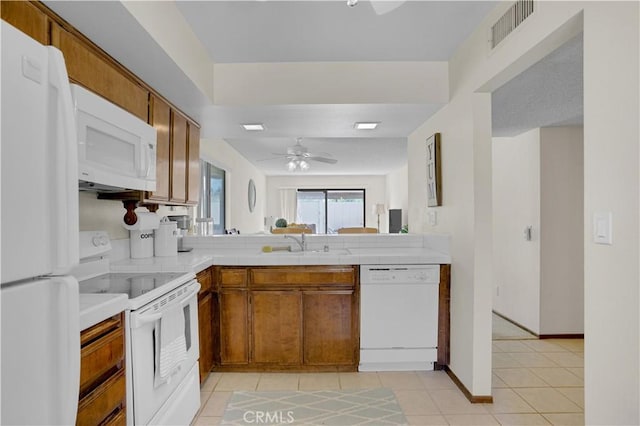 69723 Encanto Ct, Rancho Mirage, CA 92270 - kitchen with white appliances, brown cabinetry, a sink, and a ceiling fan