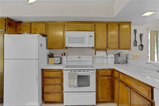 69723 Encanto Ct, Rancho Mirage, CA 92270 - kitchen with white appliances, brown cabinets, a sink, and tile counters