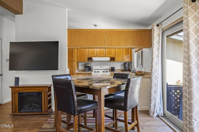 1025 Cachuma Ave Unit 32, Ventura, CA 93004 - kitchen with gas range gas stove, wood finished floors, extractor fan, and stone counters