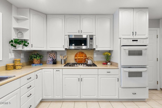 2735 Los Pinos Cir, Camarillo, CA 93012 - kitchen with appliances with stainless steel finishes, open shelves, white cabinetry, and light countertops