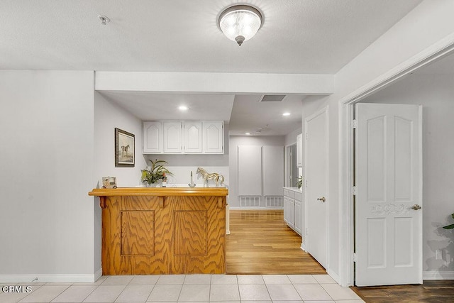 2735 Los Pinos Cir, Camarillo, CA 93012 - kitchen featuring white cabinets, light tile patterned flooring, baseboards, a peninsula, and recessed lighting