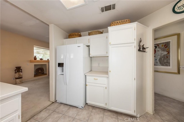 689 Twin Hills Dr, Banning, CA 92220 - kitchen featuring white refrigerator with ice dispenser, light countertops, white cabinets, and light tile patterned floors