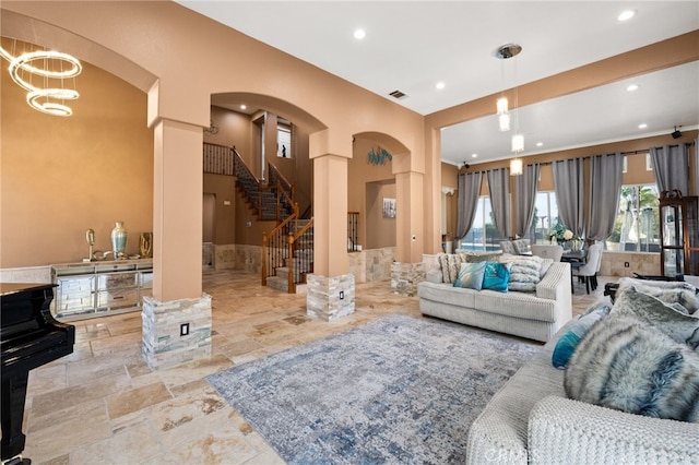 18936 Summerleaf Ln, Riverside, CA 92504 - living area with arched walkways, stone tile flooring, stairway, recessed lighting, and ornate columns