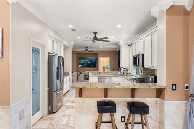 18936 Summerleaf Ln, Riverside, CA 92504 - kitchen with appliances with stainless steel finishes, a peninsula, recessed lighting, ornamental molding, and ceiling fan