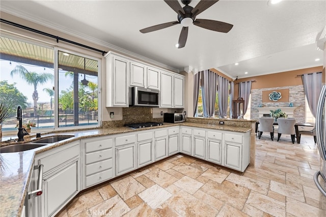 18936 Summerleaf Ln, Riverside, CA 92504 - kitchen featuring a sink, stainless steel microwave, gas stovetop, a peninsula, and stone tile flooring