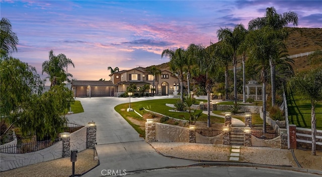 18936 Summerleaf Ln, Riverside, CA 92504 - mediterranean / spanish-style home with curved driveway, a fenced front yard, and an attached garage