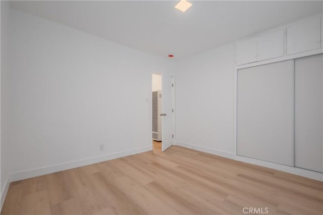 15058 Gale Ave, Hacienda Heights, CA 91745 - unfurnished bedroom featuring a heating unit, light wood-style flooring, baseboards, and a closet