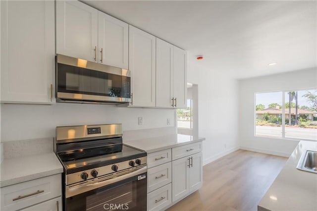 15058 Gale Ave, Hacienda Heights, CA 91745 - kitchen featuring stainless steel appliances, light wood-style flooring, light countertops, white cabinetry, and baseboards