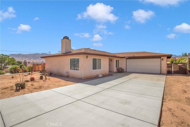 18603 Mecca St, Hesperia, CA 92345 - ranch-style home with a garage, driveway, a chimney, stucco siding, and a mountain view