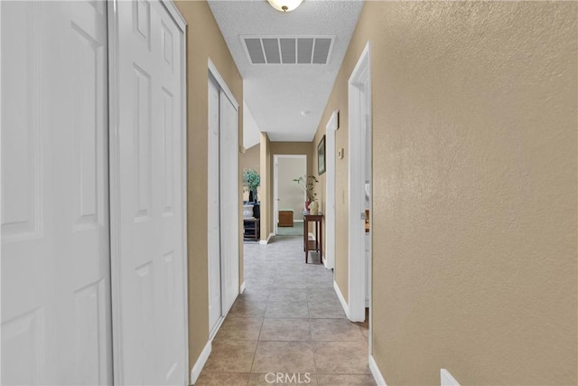 18603 Mecca St, Hesperia, CA 92345 - hallway featuring baseboards, a textured wall, light tile patterned floors, and a textured ceiling