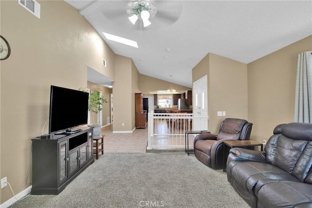 18603 Mecca St, Hesperia, CA 92345 - living room featuring a ceiling fan, vaulted ceiling, light colored carpet, baseboards, and a skylight