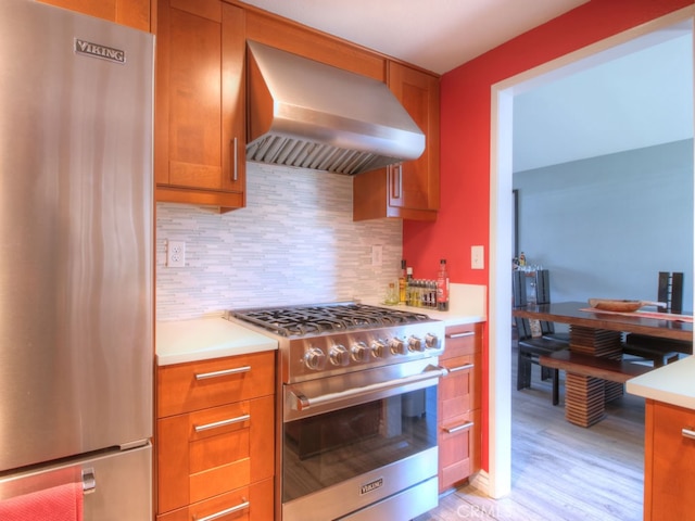 1400 Ashley Pl, Upland, CA 91784 - kitchen with stainless steel appliances, wall chimney range hood, backsplash, light wood finished floors, and light countertops