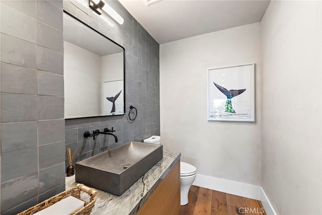 213 Avenida Princesa, San Clemente, CA 92672 - bathroom featuring tile walls, wood finished floors, toilet, vanity, and baseboards