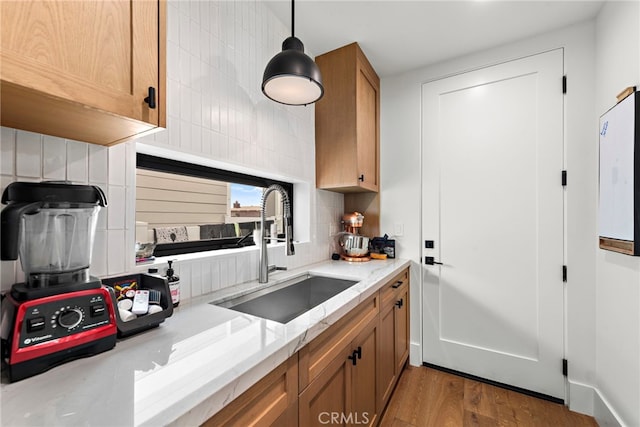 213 Avenida Princesa, San Clemente, CA 92672 - kitchen featuring a sink, brown cabinets, wood finished floors, tasteful backsplash, and light stone countertops