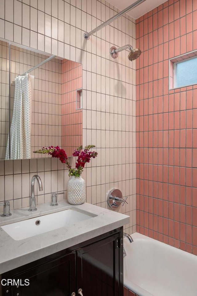 4865 Granada St, Los Angeles, CA 90042 - bathroom featuring tile walls, vanity, backsplash, and shower / tub combo