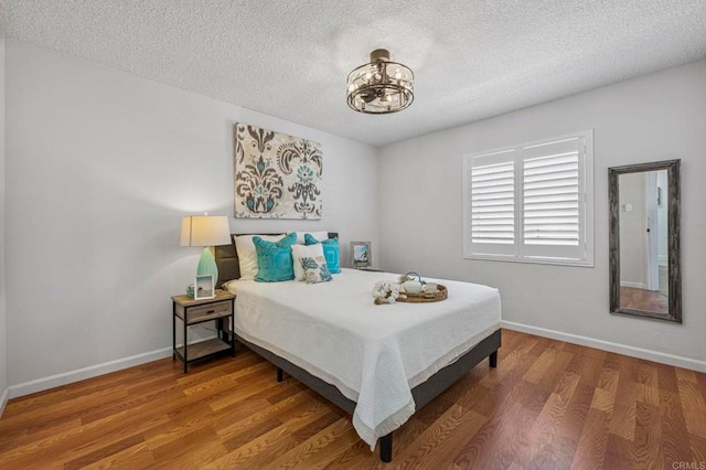 3925 Linmar Ln, Carlsbad, CA 92008 - bedroom featuring a textured ceiling, wood finished floors, and a chandelier