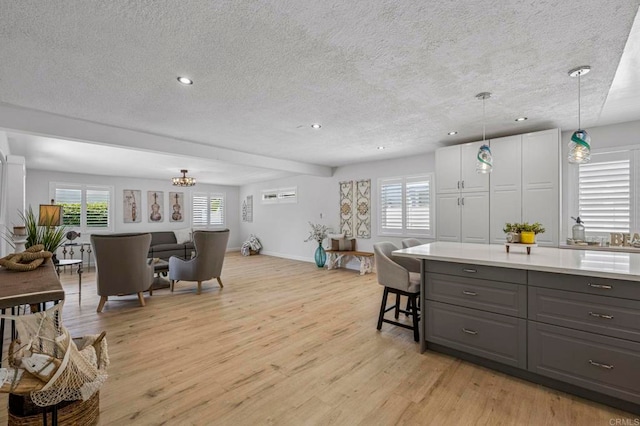 3925 Linmar Ln, Carlsbad, CA 92008 - kitchen with gray cabinets, light wood-style flooring, a textured ceiling, recessed lighting, and plenty of natural light