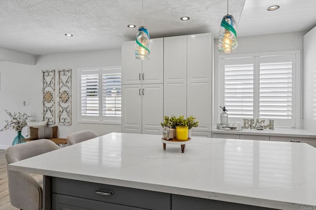3925 Linmar Ln, Carlsbad, CA 92008 - kitchen featuring recessed lighting, pendant lighting, a textured ceiling, white cabinets, and light stone counters