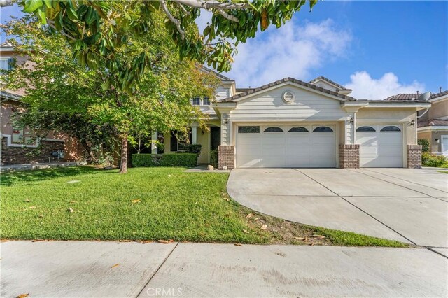 15601 N Peak Ln, Fontana, CA 92336 - view of front facade featuring brick siding, a garage, concrete driveway, a front yard, and a tiled roof