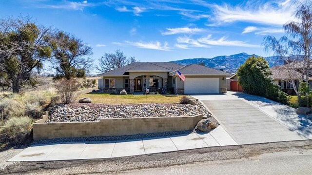 22104 Mccarthy Dr, Tehachapi, CA 93561 - ranch-style home with a garage, a mountain view, stucco siding, a front yard, and concrete driveway